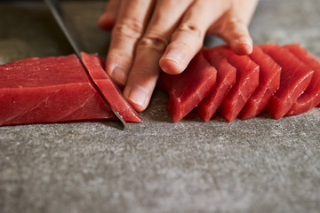 Slicing tuna saku block with sashimi knife