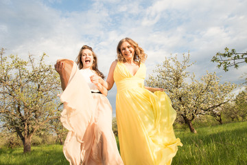 Fototapeta na wymiar Stylish girls in a retro dress. Vintage ladies in a spring park. Two women have fun