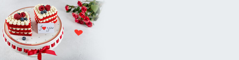 Red velvet cakes with raspberries, blueberries and whipped cream in heart shape on light...