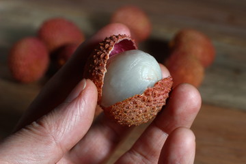 ripe lychee fruit in hand close-up