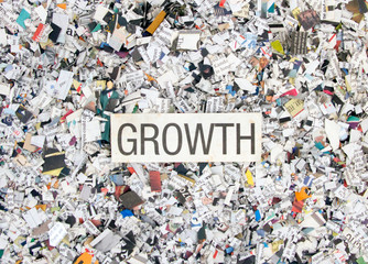Naklejka premium Newspaper confetti from above with the word GROTH