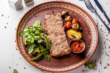 Baked veal served with grilled vegetables, mushrooms and chili sauce, restaurant dish, Top view, Horizontal orientation
