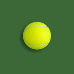 Yellow tennis ball on green background. Flat lay composition