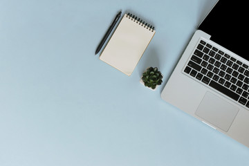 Top view workspace on blue background with notebook and pen