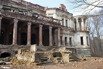 Old abandoned farmstead pavlishchev Bor in the spring through the bare branches of trees. Abandoned architectural monument in a frightening form
