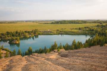Blue lake in the mountains in summer at dawn. Lake in the village of Konduki in the Tula region on abandoned sand pits.