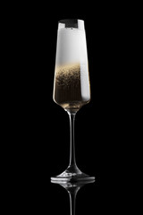 Single elegant luxury glass just filled with champagne with lots of foam isolated on black background