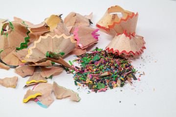 Wooden colored pencil-sharpening shavings pile on white background