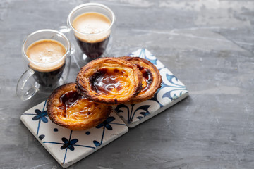 typical portuguese egg tart pastel de nata with cup of coffee on ceramic background