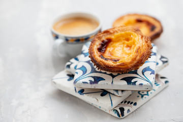 typical portuguese egg tart pastel de nata with cup of coffee on ceramic background