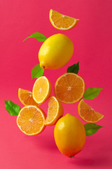 Lemons hovering in the air against bright pink background