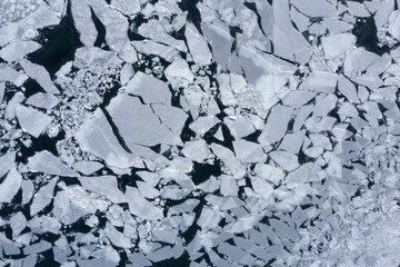 Broken sea ice with cracks and ravines.