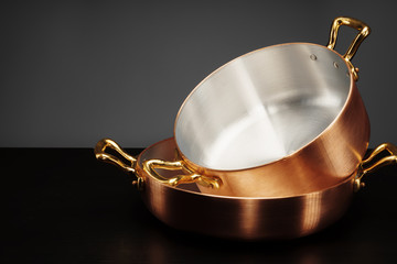 New copper cooking ware over dark background