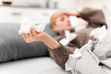 Woman sick in the bed, flu and virus infections, allergy, seasonal health issues.