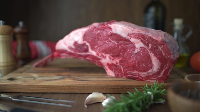 fresh raw tomahawk steak on wooden cutting board
