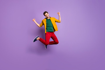Fototapeta na wymiar Full size photo of cheerful guy jump raise fists enjoy spring time discounts wear casual style outfit isolated over vibrant color background