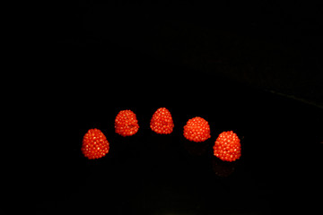 five blueberry red lke drops on circle isolated on black