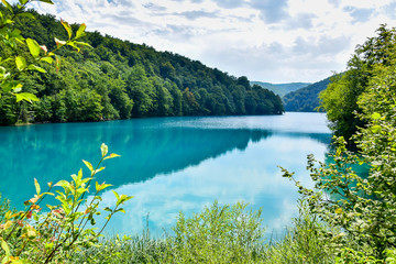 Fototapeta na wymiar Plitvice Lakes National Park, Croatia - a UNESCO World Heritage Site. Interconnected turquoise lakes. Around the lakes are trees and rocks, which are washed by the water of the lakes, river.