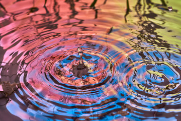 Raindrops fall on the surface of the water. The circles from the raindrops on the water surface....