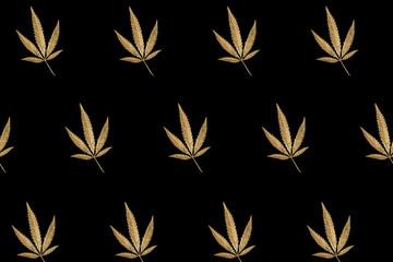 Abstract pattern golden leaves cannabis marijuana on black background in minimal branding creative...