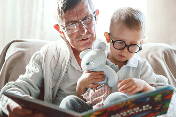 Grandfather and grandson are reading a book