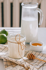Healthy breakfast of cottage cheese with sour cream, honey and lime on a marble table