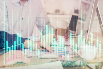 Multi exposure of chart with man typing on computer in office on background. Concept of hard work.