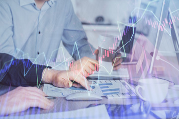 Multi exposure of chart with man typing on computer in office on background. Concept of hard work.