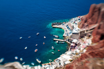 Tilt-shift view from above of a Mediterranean harbor on a bright sunny day in Santorini, Greece