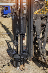 Mobile crane is loading cargo. View on construction site with machinery on construction background.
