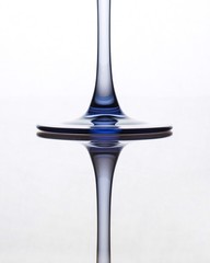 Extreme close-up glass leg on white background with reflection and blue tint