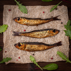 Smoked fish on a brown paper with pepper and salads