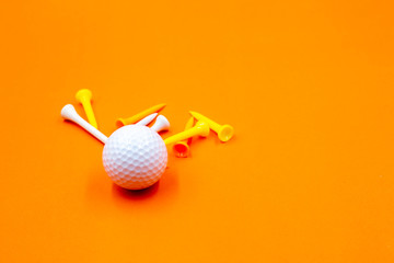 Golf ball and tees are on yellow background