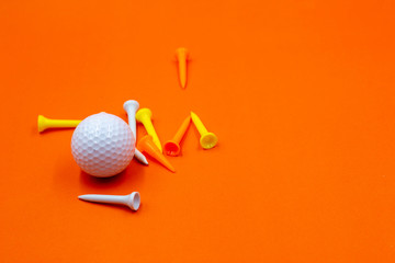 Golf ball and tee are on orange background