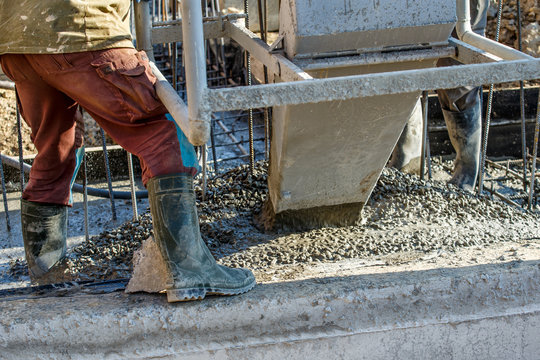 Pouring cement during for construction from concrete mixer truck car.Construction workers in the process of forming house concrete slab at the construction site
