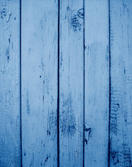 Fototapeta na wymiar painted wooden wall. grunge background texture toned in trendy Classic Blue color of the Year 2020