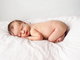 Obraz na płótnie Canvas Newborn girl. Naked newborn girl is sleeping. Newborn baby on white.