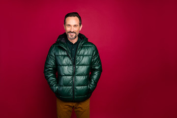 Photo of cheerful handsome man holding hand in pocket of wind breaker in trousers standing confidently isolated vivid color background © deagreez