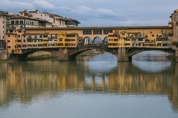 Obraz premium View of the historic Ponte Vecchio with gorgeous reflections in the Arno river during winter season, Florence, Tuscany, Italy