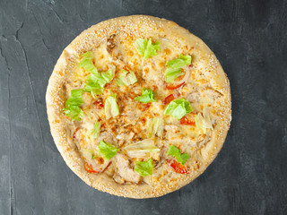 Italian pizza. With grilled chicken breast, tomatoes, lettuce, mozzarella and parmesan, Caesar dressing. Wide side. View from above. On a gray concrete background. Isolated.
