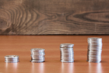 A stack of coins in ascending order. Profit growth concept. The economic growth. On wooden background