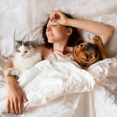 girl in bed with cat and dog - 317458278