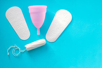 Sanitary pad, menstrual cup and tampon on pink background, space for text