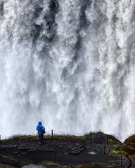 Lonely tourist near gorgeus Dettifoss waterfall - most powerful waterfall in Europe. Jokulsargljufur National Park, Iceland. Landscape photography