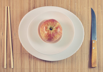 flatly the concept of healthy eating fasting simple design bamboo chopsticks a knife and an Apple in three white cups with bamboo backdrop