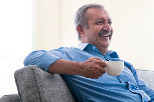 Portrait of a senior man sitting at home and drinking tea.