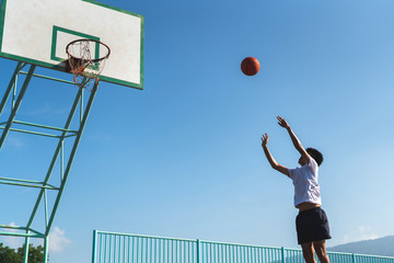 A male player throwing the ball into the basketball hoop