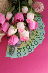 bouquet of pink roses and one hundred notes australian dollars