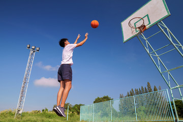 A male player throwing the ball into the basketball hoop