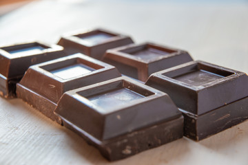 Pezzi di cioccolato fondente su tagliere bianco